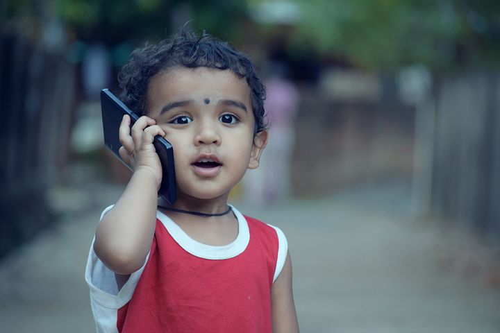 Un bambino che parla con il cellulare