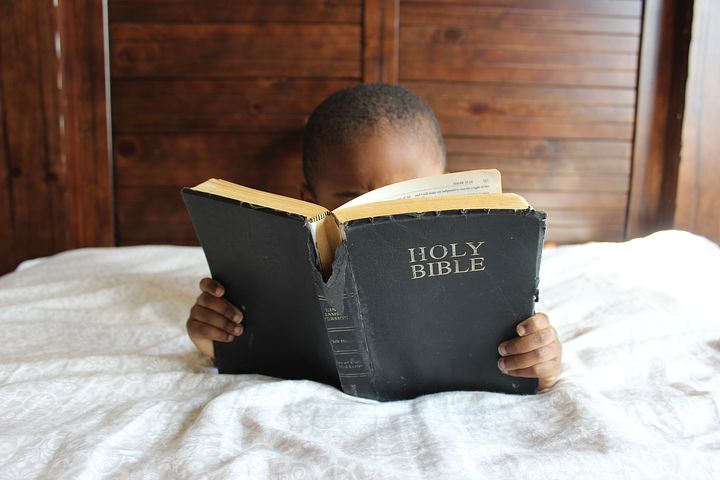 Un bambino che legge la Bibbia