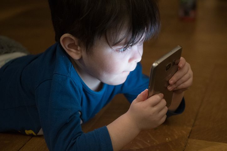 Bambino che guarda uno smartphone